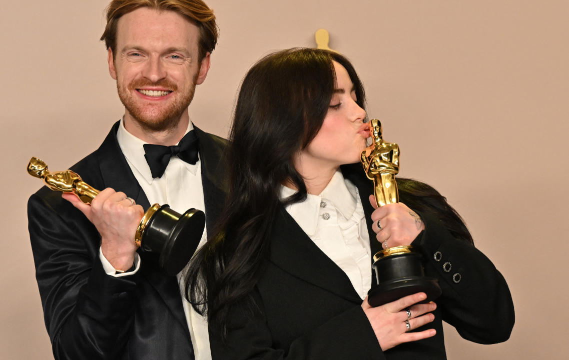 TOPSHOT - US singer-songwriter Billie Eilish and US singer-songwriter Finneas O'Connell pose in the press room with the Oscar for Best Original Song for 