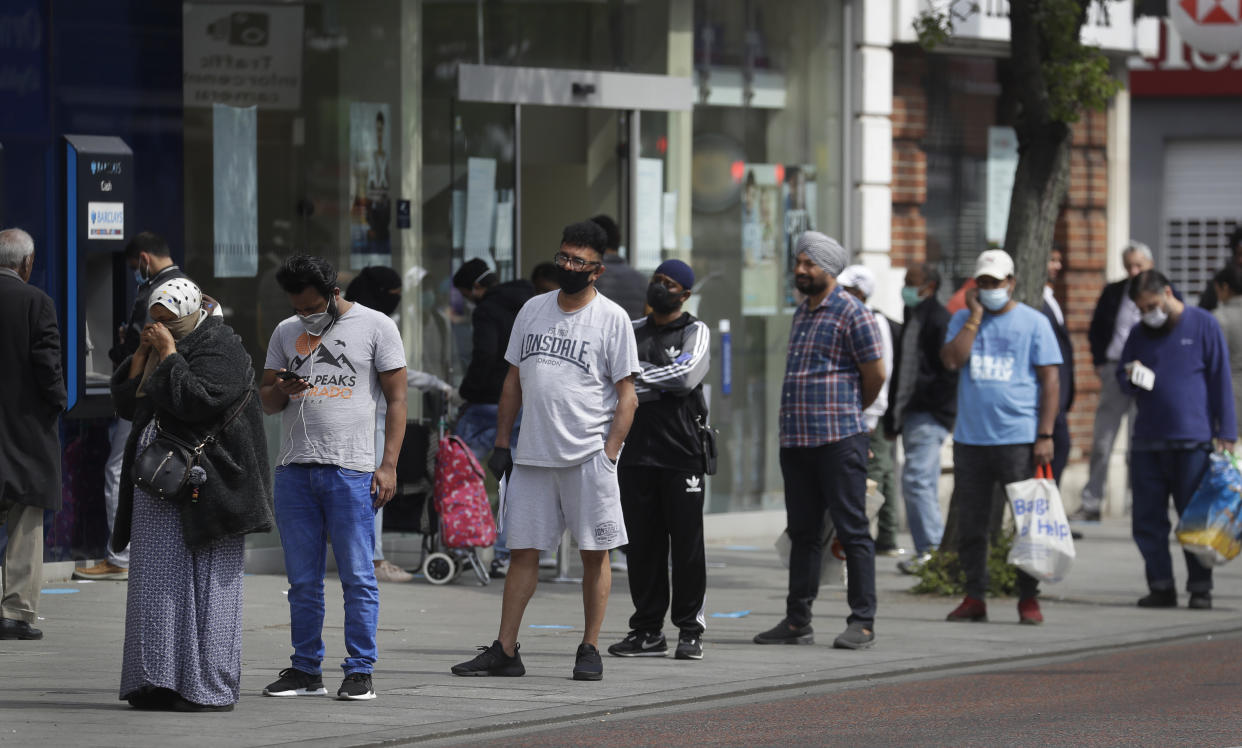 People social distance as they queue to enter a shop on a high street, as the country continues its lockdown to help curb the spread of the virus, in London, Monday, April 27, 2020. While Britain is still in lockdown, some nations have begun gradually easing coronavirus lockdowns, each pursuing its own approach but all with a common goal in mind, restarting their economies without triggering a new wave of infections. (AP Photo/Kirsty Wigglesworth)