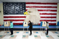 FILE - In this Nov. 3, 2020, file photo voters cast their ballots under a giant mural at Robious Elementary school on Election Day, in Midlothian, Va. As Republicans roll back access to the ballot, Democratic lawmakers have been quietly moving to expand voting rights. In Virginia, Maryland, Nevada and other states where Democrats have control, lawmakers are pushing to make it easier to cast ballots by mail, increase early voting and require greater oversight over changes to election law. (AP Photo/Steve Helber, File)