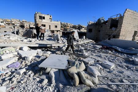 People inspect a site hit by what residents said were airstrikes carried out by the Russian air force in the town of Turmanin, in Idlib Governorate near the Syrian-Turkish border, January 25, 2016. REUTERS/Ammar Abdullah