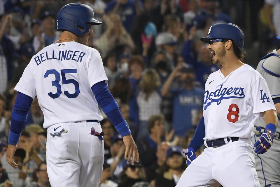 Los Angeles Dodgers' Cody Bellinger, left, looks at Zach McKinstry, who crosses home plate after hitting a two-run home run against the New York Mets during the fourth inning of a baseball game Friday, June 3, 2022, in Los Angeles. (AP Photo/John McCoy)