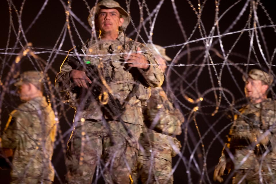 A Texas National Guard tells migrants they will not be allowed inside the concertina wire an hour before Title 42 was set to expire in El Paso, Texas on Thursday, May 11, 2023.