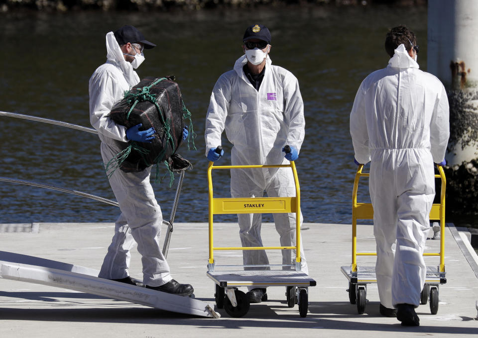 Investigators unload materials believed to be cocaine in Sydney, Tuesday, Aug. 18, 2020. Australian authorities said Tuesday they seized a large quantity of cocaine from a fishing boat in treacherous seas off the east coast. (AP Photo/Rick Rycroft)