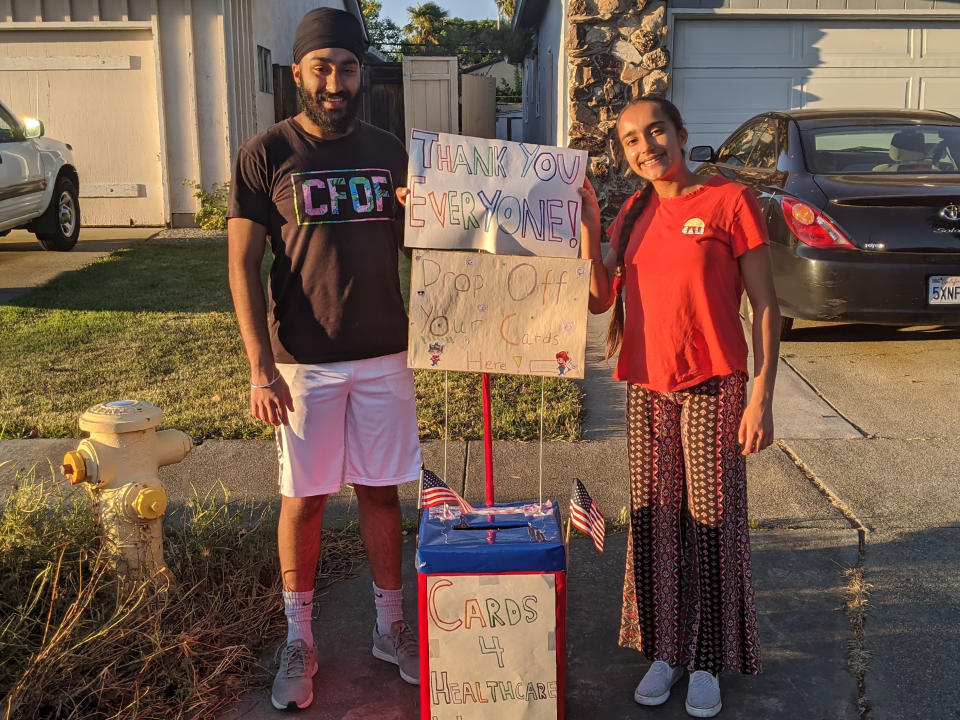 In this May 26, 2020, photo provided by Taranjit Singh Lamba, siblings Mantej Singh Lamba, 17, left, and Prabhleen Singh Lamba, 15, collect thank-you cards from community members in Fremont, Calif. The teens started the Cards 4 Covid Heroes initiative in May and have since delivered more than 250 thank-you cards to health care workers in California and Arizona. (Taranjit Singh Lamba via AP)