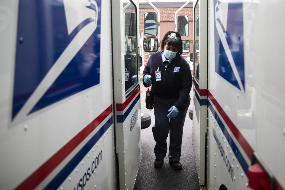 In this Wednesday, May 6, 2020, photo, United States Postal Service carrier Henrietta Dixon gets into her truck to deliver mail in Philadelphia. (AP Photo/Matt Rourke)