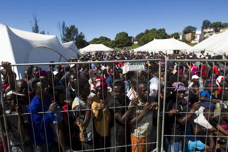 Foreign men from Malawi queue to board buses from a camp for those affected by anti-immigrant violence in Chatsworth north of Durban, April 18, 2015. REUTERS/Rogan Ward