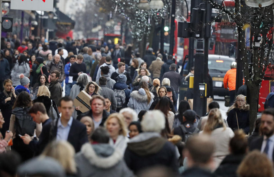 Shoppers walk along Oxford Street in London ahead of Christmas, Friday, Dec. 22, 2017. (AP Photo/Frank Augstein)