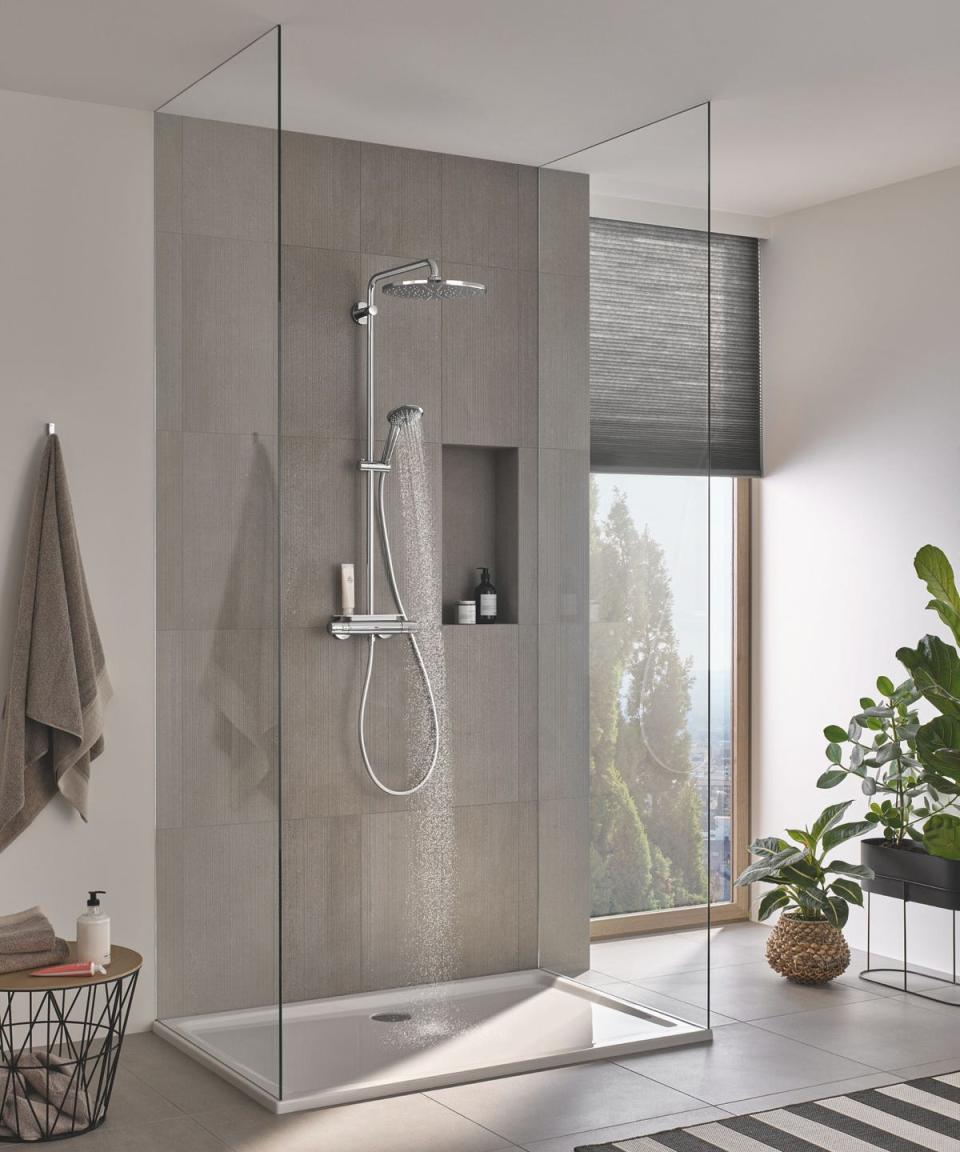 modern shower with grey large tiles and floor to ceiling window