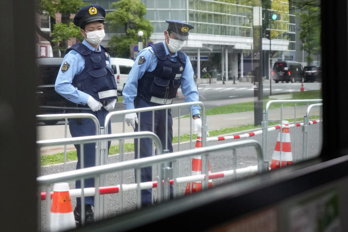 Police officers preparing fence for the road block on the street are seen though a commuter bus during the Group of Seven (G-7) nations' meetings Saturday, May 20, 2023, in Hiroshima, western Japan. (AP Photo/Eugene Hoshiko)