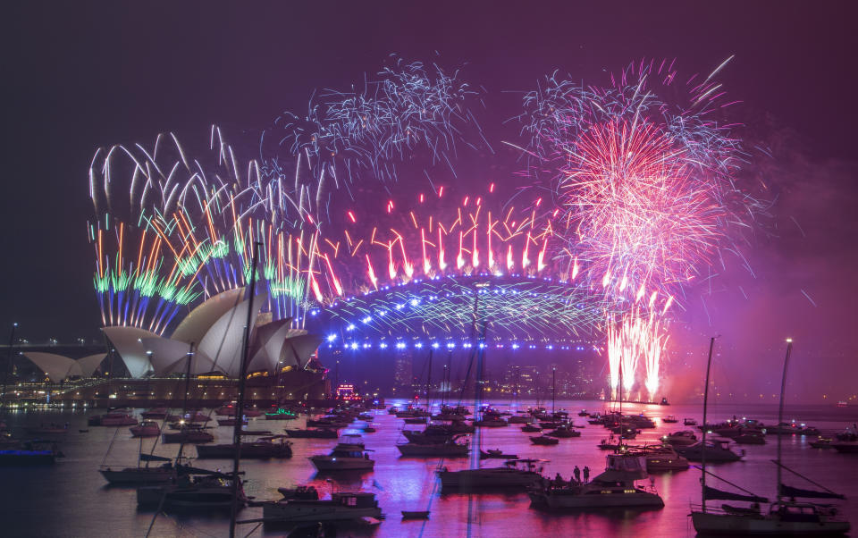 Fireworks explode over the Sydney Opera House and Harbour Bridge as New Year celebrations begin in Sydney, Australia, Friday, Jan. 1, 2021. One million people would usually crowd the Sydney Harbor to watch the annual fireworks that center on the Sydney Harbour Bridge. But this year authorities advised revelers to watch the fireworks on television as the two most populous states, New South Wales and Victoria battle to curb new COVID-19 outbreaks. (AP Photo/Mark Baker)