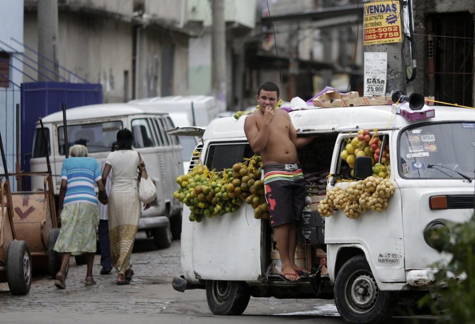 A fruit vendor stands at his kombi van at the Mare slums complex in Rio de Janeiro