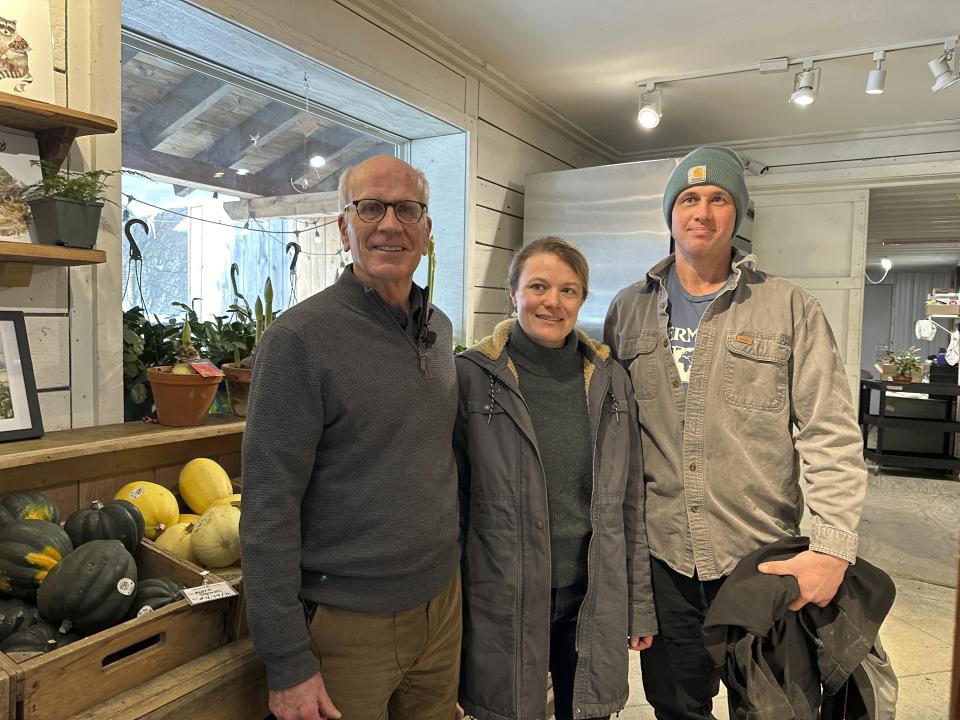 U.S. Sen. Peter Welch, left, stands with Karin Bellemare and Jon Wagner, owners of Bear Roots Farm, at their farm store in Middlesex, Vt. on Friday, Jan. 26, 2024. Since catastrophic flooding hit Vermont in July and upended plantings, some farmers are trying to figure out how to get through the next season. (AP Photo/Lisa Rathke)