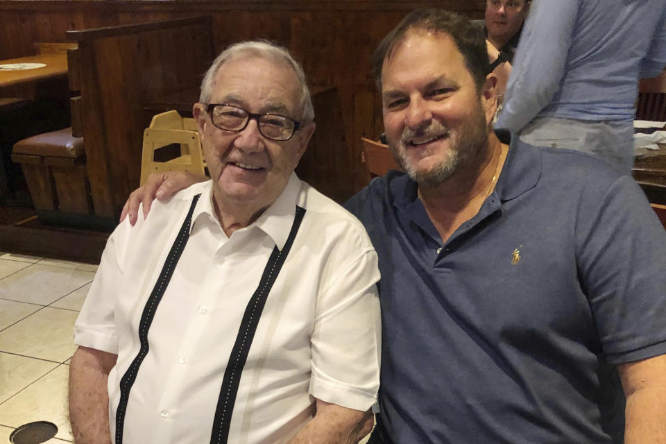 In this photo provided by Charlie Vallejo, Dr. Carlos Vallejo, right, celebrates Dr. Jorge Vallejo's birthday on June 12, 2020, at a Cuban restaurant in Pembroke Pines, Fla. Dr. Jorge Vallejo was hospitalized the night before Father's Day due to COVID-19. His son, the internist Dr. Carlos Vallejo, who was treating elderly residents infected with the coronavirus, was taken to another hospital hours later with shortness of breath due to the virus. They both died at ages 89 and 57, respectively. Dr. Jorge Vallejo, his wife and two sons arrived from Cuba in 1965 in an old navy torpedo boat. (Charlie Vallejo via AP)