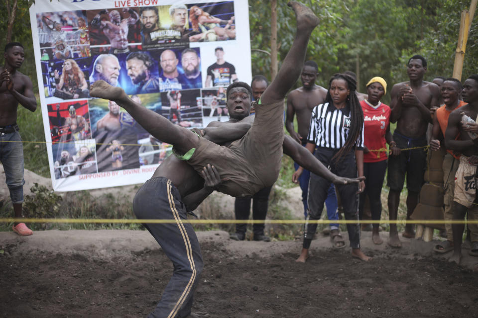 Amateur wrestlers tangle in what is known as Soft Ground Wrestling, in Kampala, Uganda March 20, 2024. The open-air training sessions, complete with an announcer and a referee, imitate the pro-wrestling contests the youth watch on television. (AP Photo/Patrick Onen)