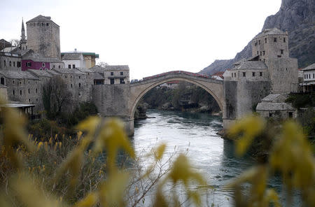Old Bridge is seen with poster which reads: "The old bridge surfaced for the ones who love it" during a television broadcast of the appeal trial in the Hague, Netherlands, for six Bosnian Croat senior wartime officials accused of war crimes against Muslims in Bosnia's 1992-1995 war, in Mostar, Bosnia and Herzegovina November 29, 2017. REUTERS/Dado Ruvic