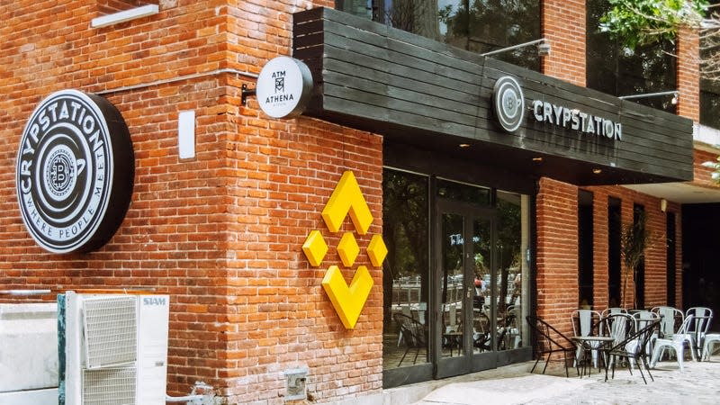 A building reading Crypstation with the Binance logo outside the door