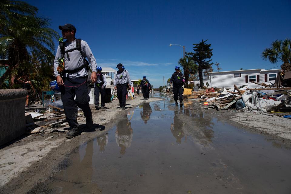 Members of an Urban Search and Rescue team from Indiana move through a San Carlos Island mobile home park near Fort Myers Beach on Monday, Oct. 3, 2022.