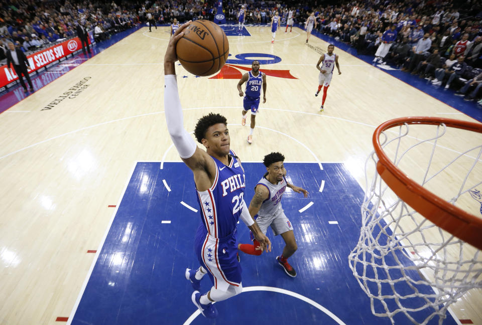 Philadelphia 76ers' Matisse Thybulle (22) goes up for a dunk past Detroit Pistons' Christian Wood (35) during the first half of an NBA basketball game, Wednesday, March 11, 2020, in Philadelphia. (AP Photo/Matt Slocum)