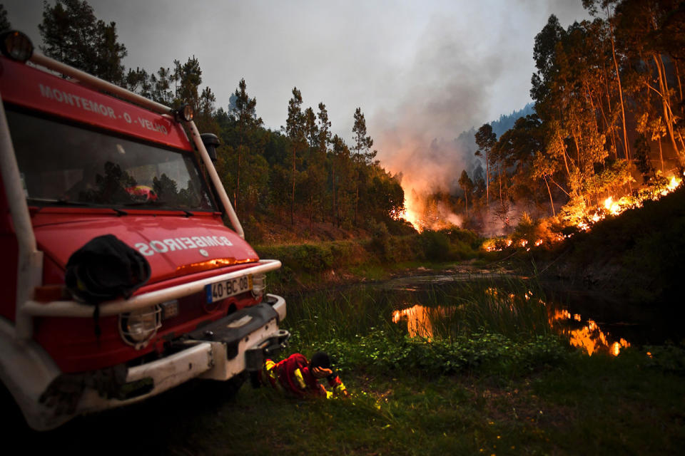 <p>A firefighter rests next to fire combat truck during a wildfire at Penela, Coimbra, central Portugal, on June 18, 2017. (Patricia De Melo Moreira/AFP/Getty Images) </p>