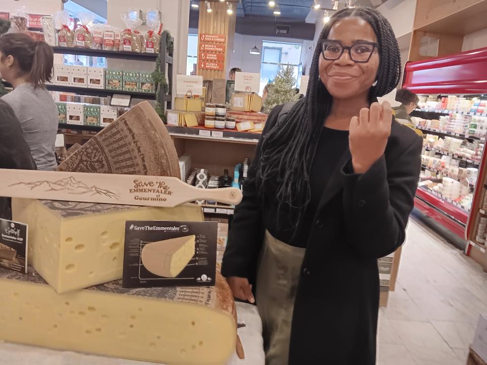 tary talking a photo with a wheel of cheese at Murray cheese shop in nyc