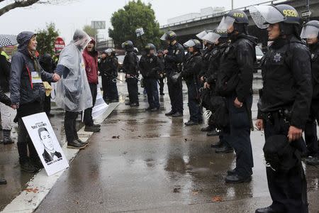 Demonstrators face off with police while blocking doors to the Oakland Police Department to protest against killings of unarmed black men by police officers in Oakland, California December 15, 2014. REUTERS/Robert Galbraith