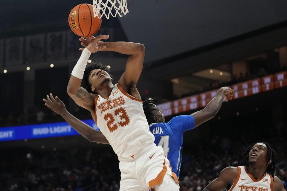 Texas forward Dillon Mitchell (23) and Creighton forward Arthur Kaluma (24) reach for a rebound during the first half of an NCAA college basketball game in Austin, Texas, Thursday, Dec. 1, 2022. (AP Photo/Eric Gay)