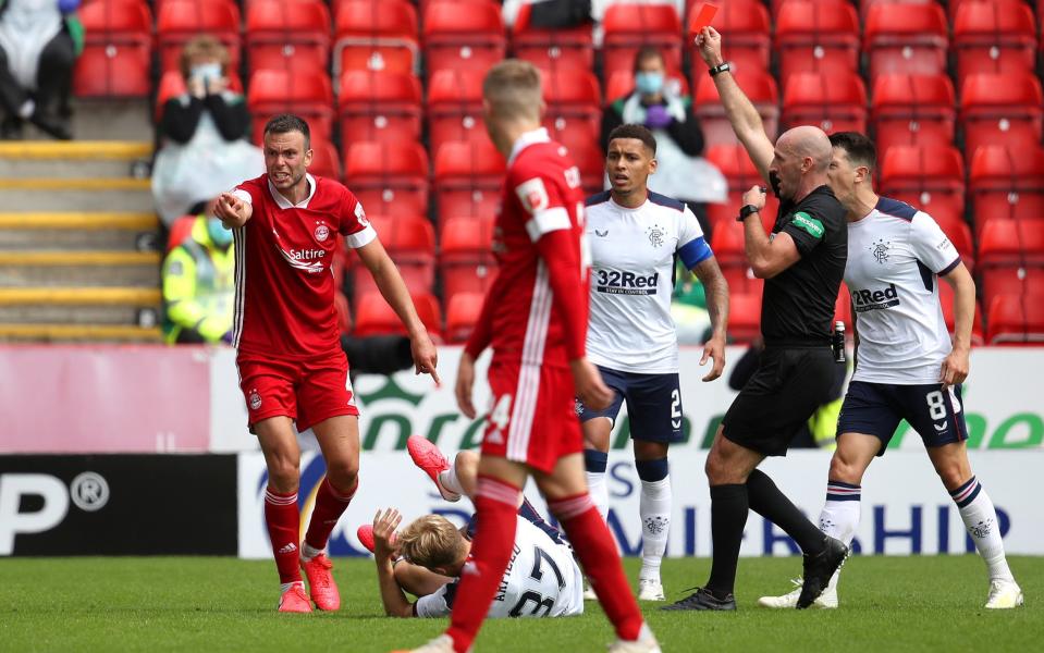 Andrew Considine of Aberdeen is shown a red card by referee Bobby Madden after fouling Scott Arfield of Rangers FC - GETTY IMAGES