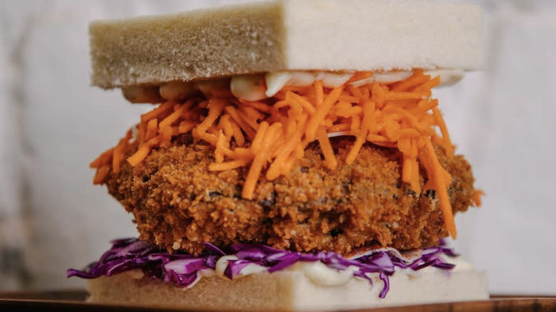 Closeup of portobello katsu sandwich with shredded carrots and cabbage