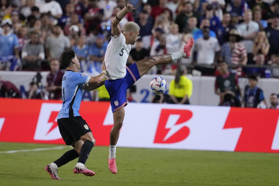 Antonee Robinson, right, of the United States, is defended by Uruguay's Facundo Pellistri, left, during a Copa America Group C soccer match, Monday, July 1, 2024, in Kansas City, Mo. (AP Photo/Ed Zurga)