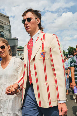 Un invité arrive au All England Lawn Tennis & Croquet Club pendant le tournoi de Wimbledon, à Londres, en juillet 2023. Fondé en 1868, ce club privé organise le tournoi de tennis, créé en 1870.. PHOTO SIMBARASHE CHA/THE NEW YORK TIMES