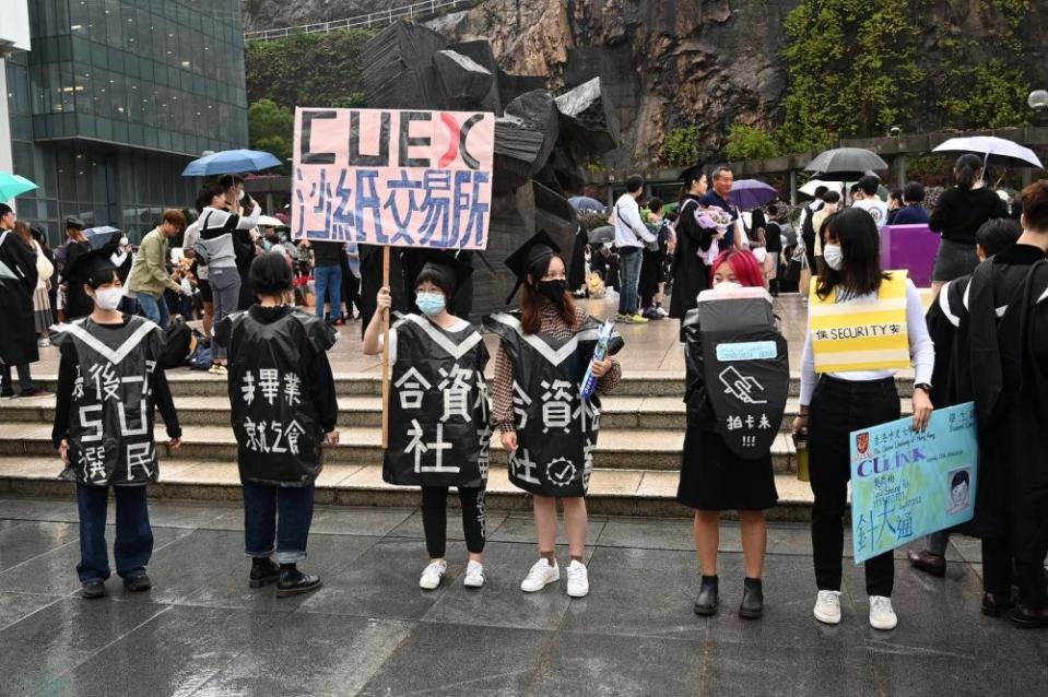 香港中文大學11月24日舉行畢業禮，期間有學生展示標語並舉起道具抗議校政。（大學社區報圖片）