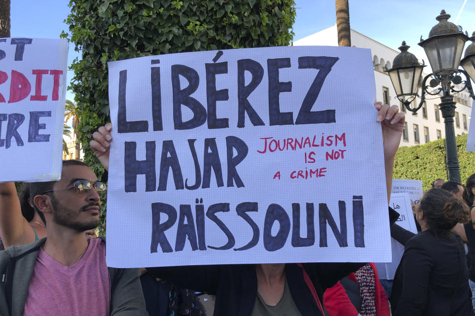 Demonstrators, including prominent activists and journalists, demonstrate with a placerd reading "Free Hajar Raissouni" in front of Parliament in Rabat, Morocco, Wednesday Oct. 2, 2019. Several dozens of Moroccan activists and journalists protested for the release of jailed journalist Haja Raissouni on Wednesday, warning that the one year prison term handed to her last Monday threatens condition of women and civil rights in the country. (AP Photo/Nadine Achoui-Lesage )