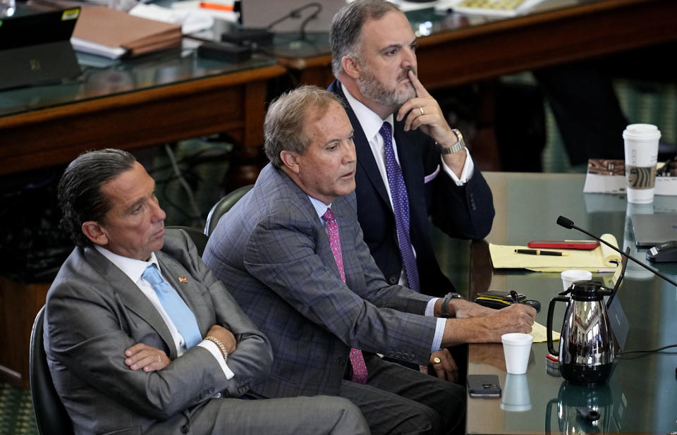 Suspended Texas state Attorney General Ken Paxton, center, sits with his attorneys Tony Buzbee, left, and Mitch Little, right, as his impeachment trial continues in the Senate Chamber at the Texas Capitol, Friday, Sept. 15, 2023, in Austin, Texas. (AP Photo/Eric Gay)