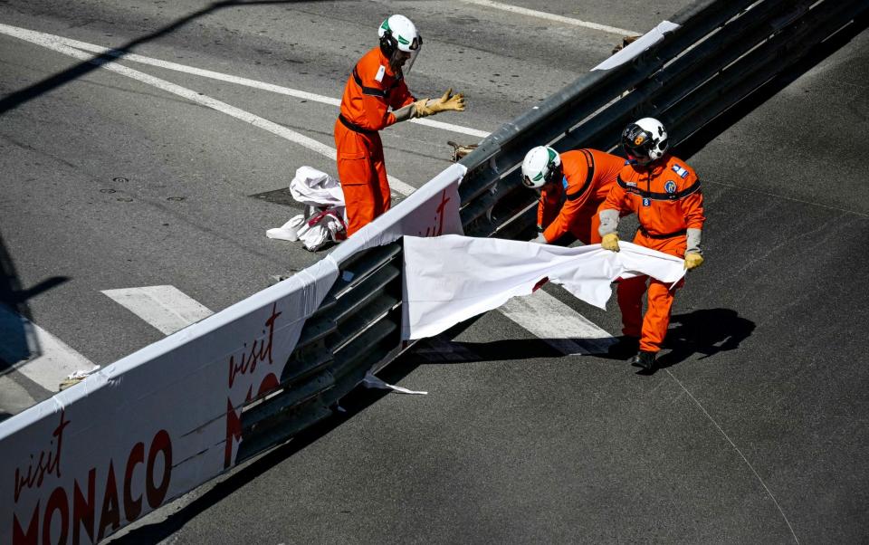 Race marshalls remove stickers from the track safety rails