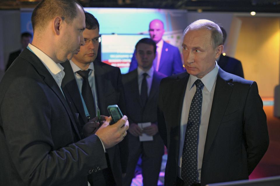 Russia's President Vladimir Putin (R) listens to explanations as he attends an exhibition on internet projects, part of a forum dedicated to internet entrepreneurial business, in Moscow, June 10, 2014. Putin said on Tuesday a fight against illegal content on the Internet should not become a fight against freedom, seeking to calm fears over a possible clampdown on media and social networking sites. REUTERS/Alexei Druzhinin/RIA Novosti/Kremlin (RUSSIA - Tags: POLITICS SCIENCE TECHNOLOGY BUSINESS) ATTENTION EDITORS - DISTRIBUTED, EXACTLY AS RECEIVED BY REUTERS, AS A SERVICE TO CLIENTS. THIS IMAGE HAS BEEN SUPPLIED BY A THIRD PARTY. IT IS DISTRIBUTED, EXACTLY AS RECEIVED BY REUTERS, AS A SERVICE TO CLIENTS