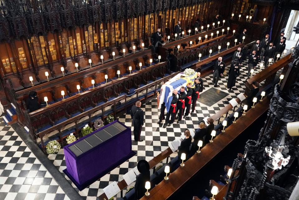 Britain's Queen Elizabeth II watches as pallbearers carry the coffin of the Duke of Edinburgh during his funeral at St. George's Chapel in Windsor Castle in 2021.