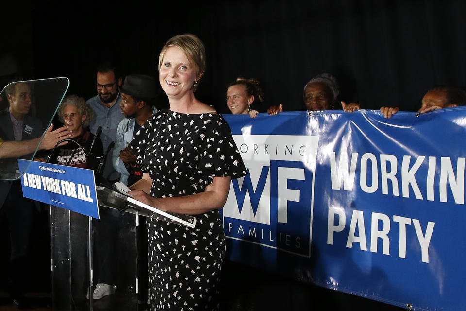 Cynthia Nixon stands at a lectern in front of a banner reading: Working Families Party.