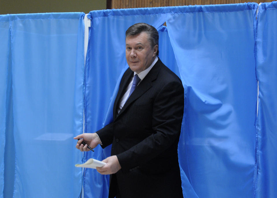 Ukrainian President Viktor Yanukovich leaves a booth for voting at a polling station during parliamentary elections in Kiev, Ukraine, Sunday, Oct. 28, 2012. (AP Photo/Sergei Chuzavkov)