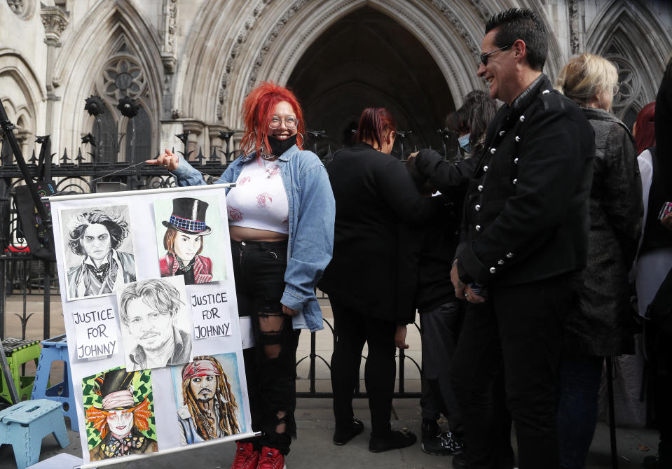 US Actor Johnny Depp supporters wait for the actor to arrive, outside the High Court in London, Tuesday, July 28, 2020. Hollywood actor Johnny Depp is suing News Group Newspapers over a story about his former wife Amber Heard, published in The Sun in 2018 which branded him a 'wife beater', a claim he denies. (AP Photo/Frank Augstein)