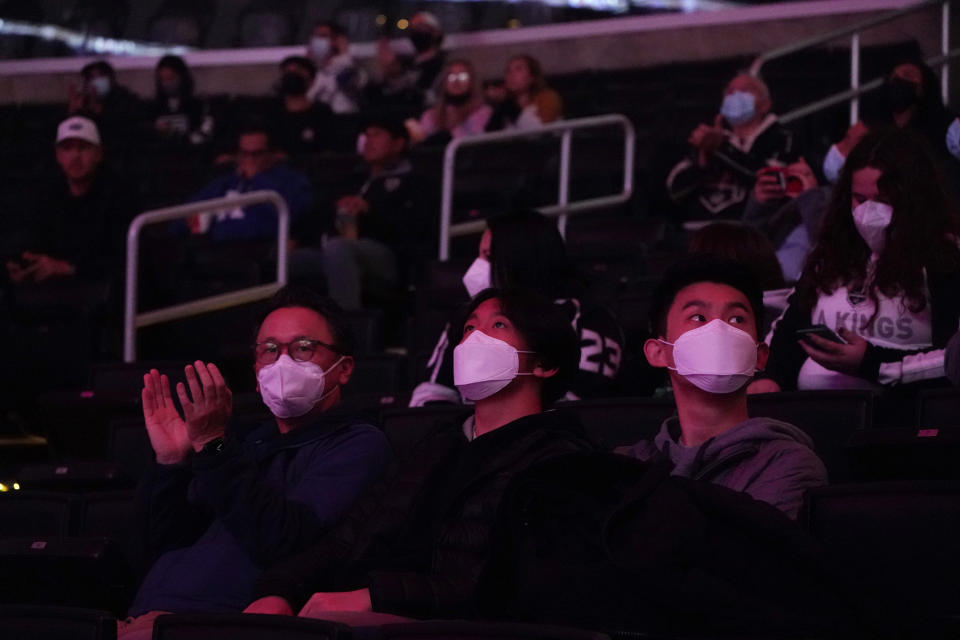 FILE - Fans wear masks inside the arena before an NHL hockey game between the Los Angeles Kings and the Nashville Predators on Thursday, Jan. 6, 2022, in Los Angeles. Americans who have been clamoring for an end to mask-wearing have welcomed new guidance from the Centers for Disease Control and Prevention. It says healthy people in most areas of the country can safely stop wearing masks. But others remain wary that the pandemic could throw a new curveball. (AP Photo/Marcio Jose Sanchez, File)