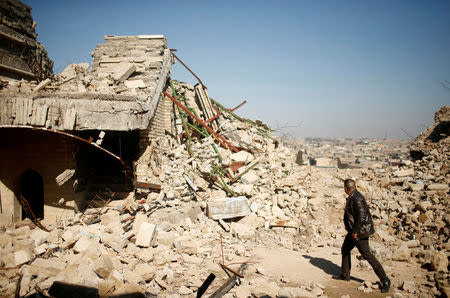 FILE PHOTO: An Iraqi man walks past a destroyed tomb of the Prophet Jonah (Nabi Younes) in the eastern side of Mosul, Iraq March 9, 2017. REUTERS/Suhaib Salem/File Photo