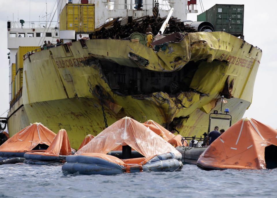 A cluster of life rafts floats near the cargo ship Sulpicio Express Siete Saturday Aug. 17, 2013, a day after it collided with a passenger ferry off the waters of Talisay city, Cebu province in central Philippines. Divers combed through a sunken ferry Saturday to retrieve the bodies of more than 200 people still missing from an overnight collision with a cargo vessel near the central Philippine port of Cebu that sent passengers jumping into the ocean and leaving many others trapped. At least 28 were confirmed dead and hundreds rescued. The captain of the ferry MV Thomas Aquinas, which was approaching the port late Friday, ordered the ship abandoned when it began listing and then sank just minutes after collision with the MV Sulpicio Express, coast guard deputy chief Rear Adm. Luis Tuason said. (Bullit Marquez/AP)