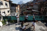 Manoel Pereira Costa (L), known as "Master Manel", plays the berimbau next to his three sons in the Rocinha favela, in Rio de Janeiro, Brazil, July 25, 2016. REUTERS/Bruno Kelly