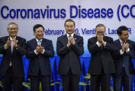 China's Foreign Minister Wang Yi, center applauds after posing for a group photo with some of the Foreign ministers of The Association of Southeast Asian Nations (ASEAN) from left, Thailand's Foreign Minister Don Pramudwinai, Vietnam's Deputy Prime Minister and Foreign Minister Phạm Binh Minh, Philippines' Foreign Affaires Secretary Teodoro Locsin Jr., and Laos Foreign Minister Saleumxay Kommasith, ahead of the Special ASEAN-China Foreign Ministers' meeting on the Novel Coronavirus Pneumonia in Vientiane, Laos, Thursday, Feb. 20, 2020. (AP Photo/Sakchai Lalit)