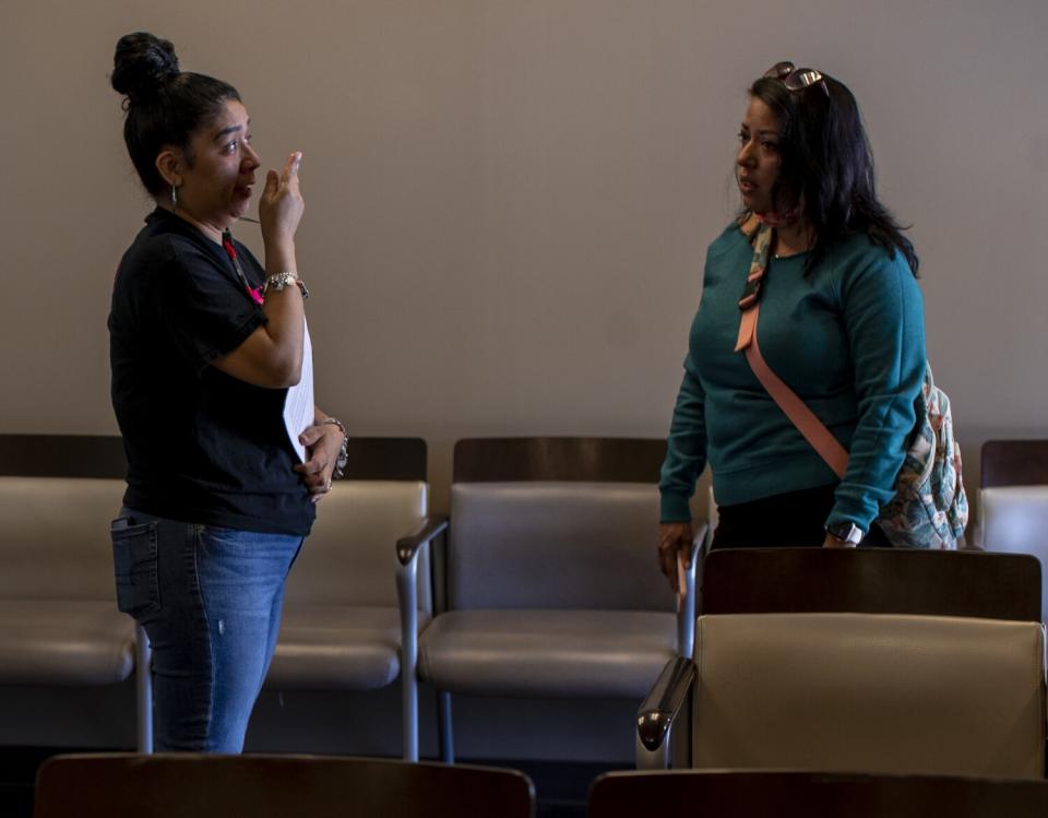 A crying woman speaks to another woman