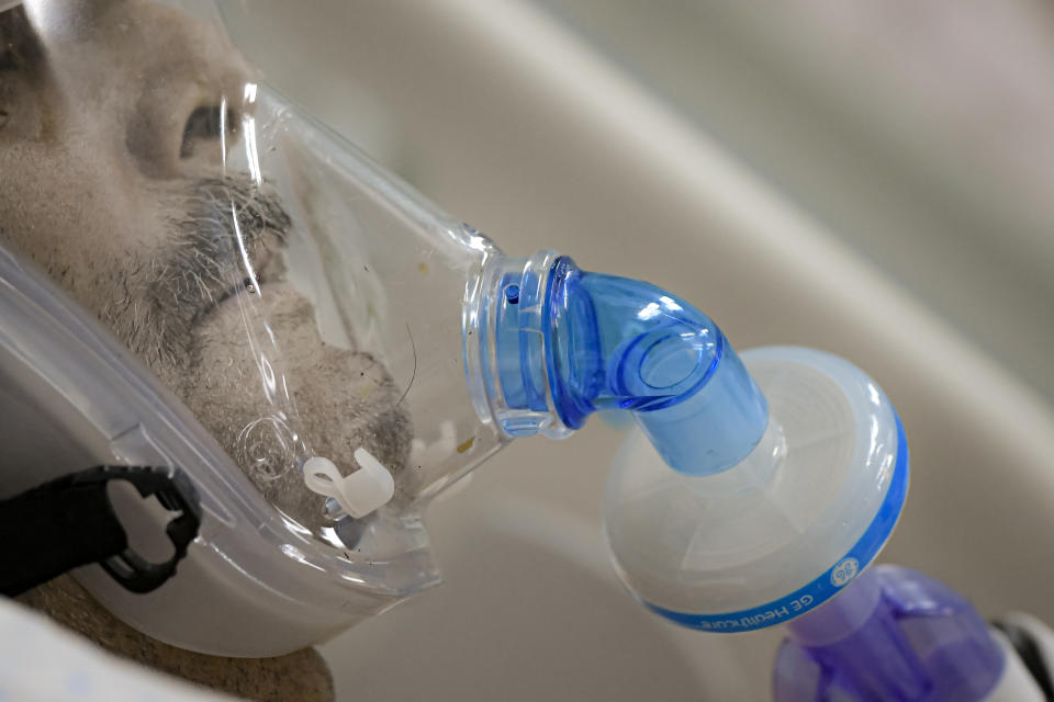 A man breathes through an oxygen mask at the COVID-19 ICU unit of the Marius Nasta National Pneumology Institute in Bucharest, Romania, Thursday, Sept. 23, 2021. Daily new coronavirus infections in Romania, a country of 19 million, have grown exponentially over the last month, while vaccine uptake has declined to worrying lows. Government data shows that 91.5% of COVID-19 deaths in Romania between Sept. 18-23 were people who had not been vaccinated. (AP Photo/Andreea Alexandru)