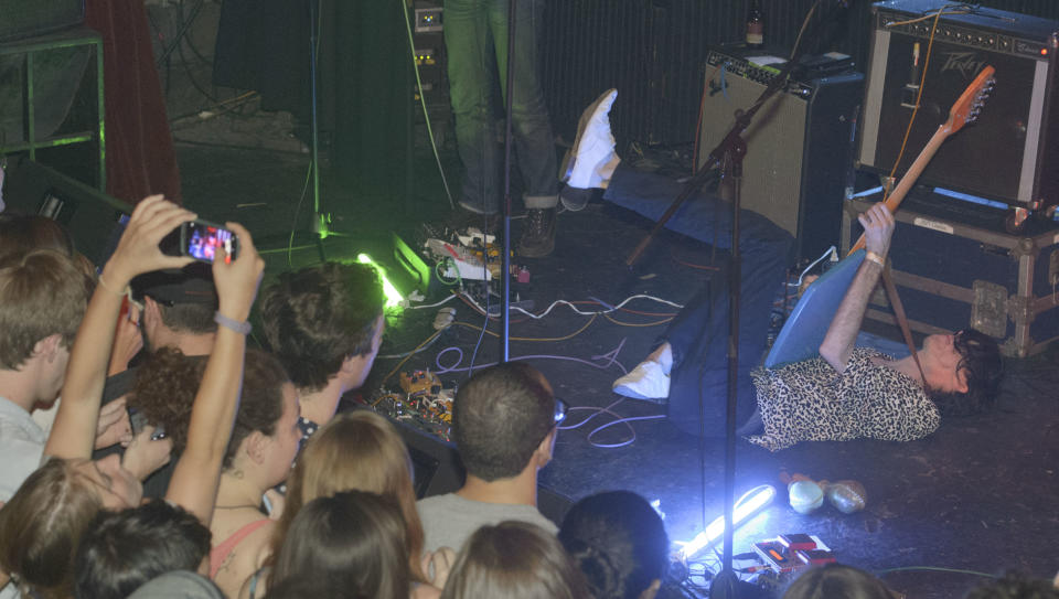 Bradford Cox plays his guitar on the stage floor along with other members of the indie rock group Deerhunter, perform at One Eyed Jack's in the French Quarter in New Orleans, Monday, April 29, 2013. (AP Photo/Matthew Hinton)