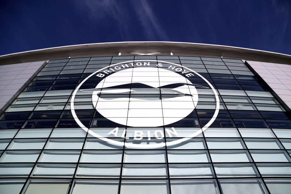 FILE - This Jan, 18, 2020 file photo shows a general view of the club crest on the side of the AMEX Stadium, home to Brighton & Hove Albion, Brighton, England. A Brighton player tested positive for the coronavirus as Premier League clubs prepare for talks on Monday, May 11 about how to resume the competition during the pandemic. The southern England club told The Associated Press there is no need for other members of the squad or coaches to self-isolate because players have only worked in isolation when at the training base. (Gareth Fuller/PA via AP, file)