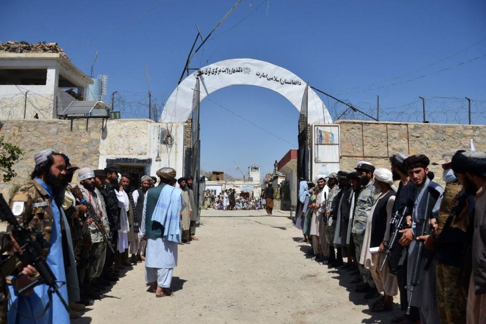 Taliban soldiers stand guard as inmates imprisoned for drug use wait to be released from Kandahar Central Prison in September last year (AFP via Getty)