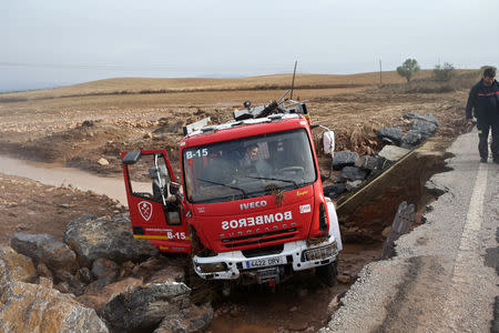 Firefighters check a destroyed firefighter truck on a road where a firefighter died as heavy rain and flash floods hit Campillos, southern Spain, October 21, 2018. REUTERS/Jon Nazca